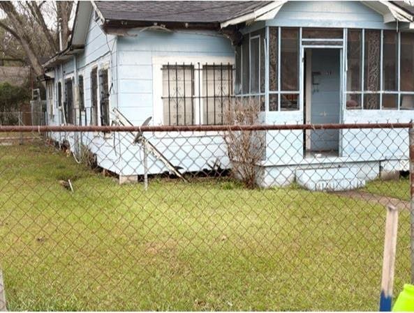 view of home's exterior featuring a lawn and a sunroom