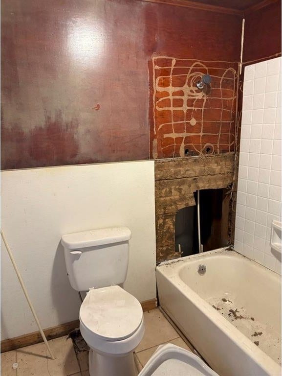 bathroom featuring tile patterned floors, toilet, and a tub