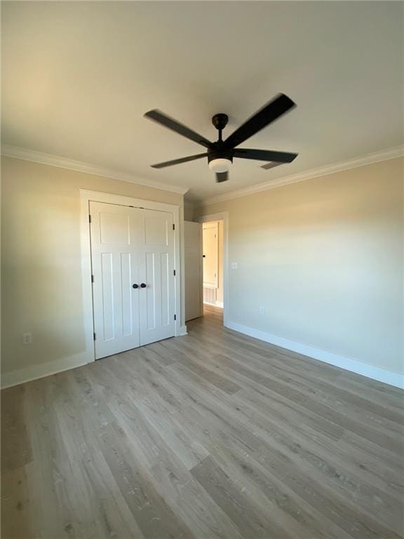 unfurnished bedroom featuring ceiling fan, ornamental molding, and light hardwood / wood-style flooring