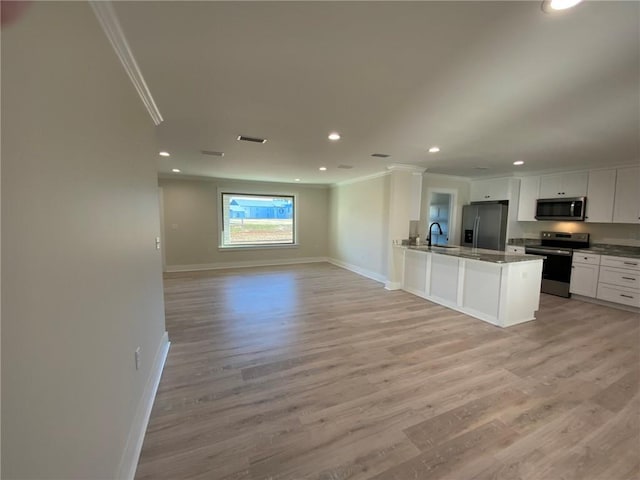 kitchen featuring sink, light wood-type flooring, ornamental molding, appliances with stainless steel finishes, and white cabinetry