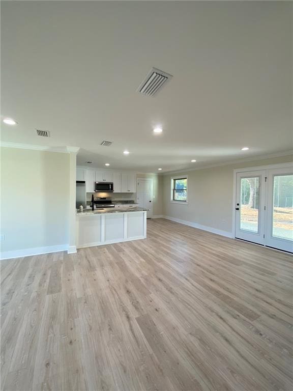 unfurnished living room with light hardwood / wood-style floors and crown molding