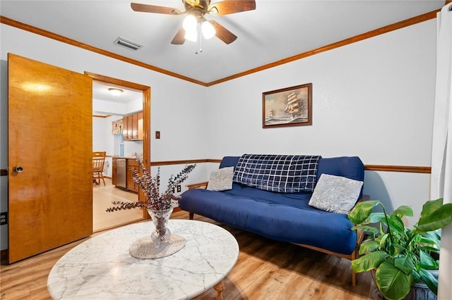 living room featuring ceiling fan, ornamental molding, and hardwood / wood-style flooring