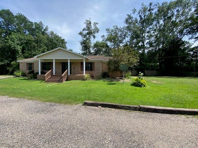 ranch-style house featuring a front yard and covered porch