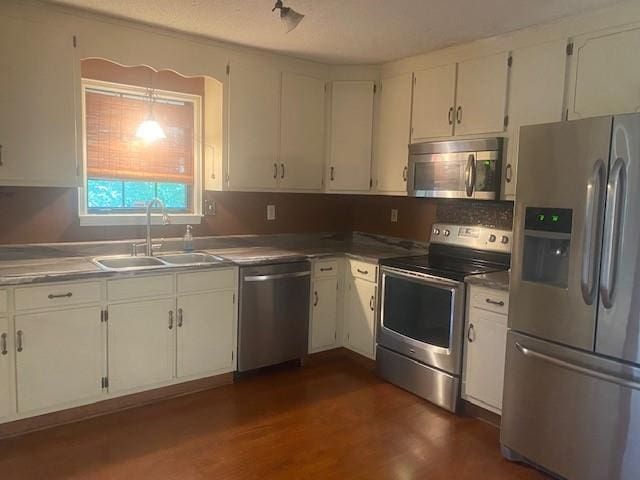 kitchen featuring white cabinetry, appliances with stainless steel finishes, dark wood-type flooring, and sink