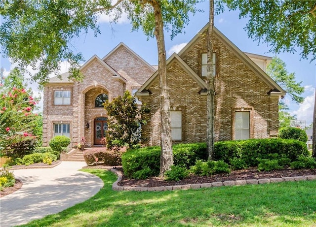 traditional-style house featuring brick siding and a front lawn