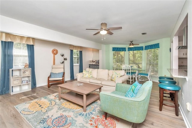 living room featuring ceiling fan and light hardwood / wood-style flooring