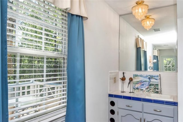 bathroom with vanity, a wealth of natural light, and a chandelier