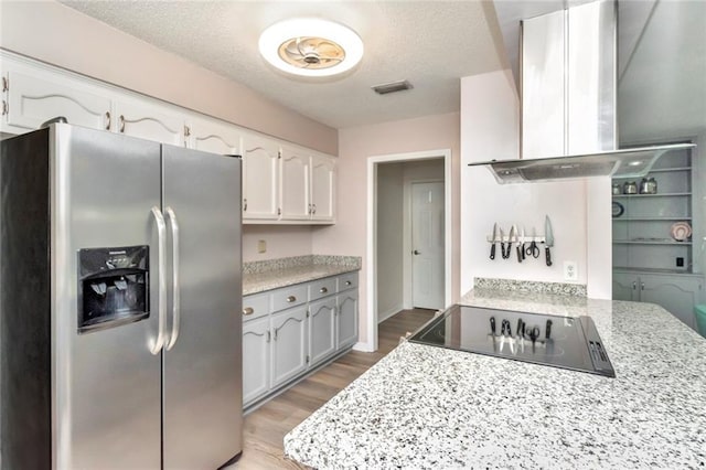 kitchen featuring white cabinetry, stainless steel fridge, light hardwood / wood-style flooring, and island range hood