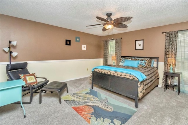 bedroom featuring carpet flooring, ceiling fan, and a textured ceiling