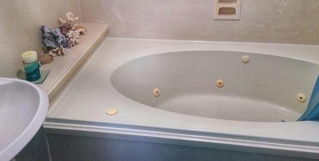 bathroom featuring a tub to relax in and sink