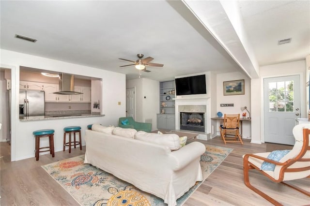 living room featuring ceiling fan and light hardwood / wood-style floors