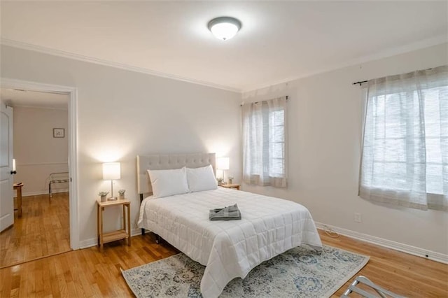 bedroom featuring ornamental molding and light wood-type flooring