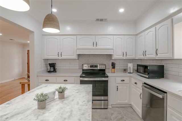 kitchen featuring decorative backsplash, decorative light fixtures, stainless steel appliances, and white cabinets