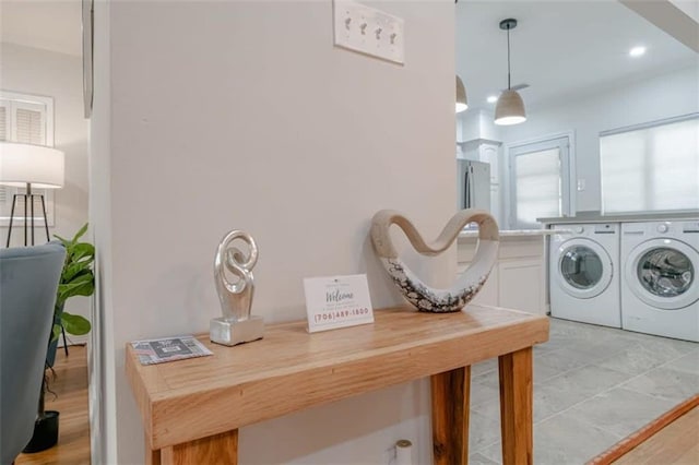 laundry room with light hardwood / wood-style floors and washing machine and clothes dryer