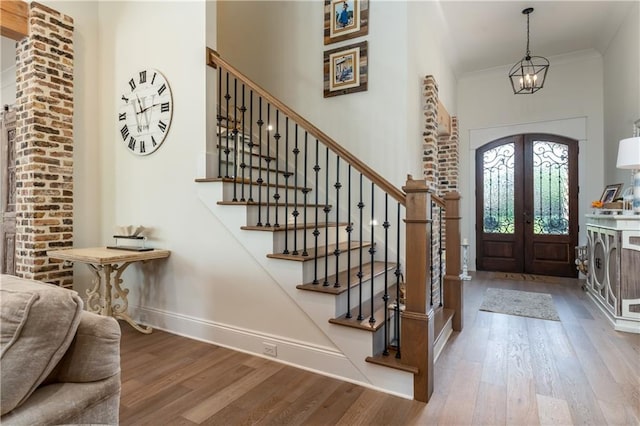 foyer with stairs, baseboards, french doors, and wood finished floors