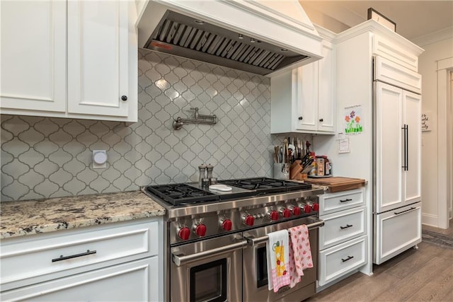kitchen featuring white cabinetry, high end appliances, premium range hood, and wood finished floors