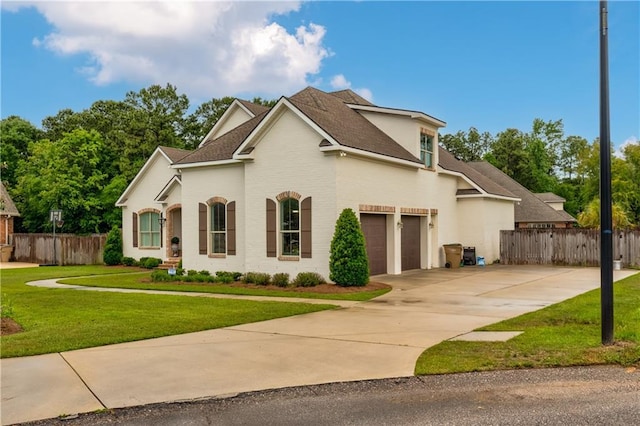 view of front of home featuring a front yard, fence, and a garage