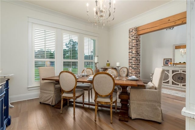 dining area with an inviting chandelier, ornamental molding, baseboards, and wood finished floors