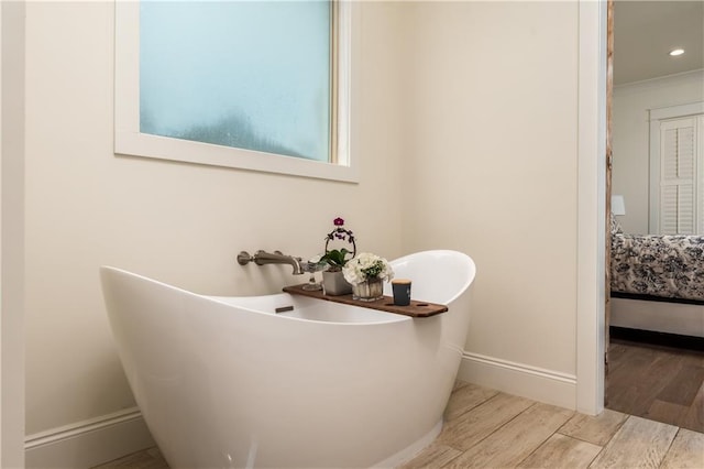 ensuite bathroom with recessed lighting, baseboards, ensuite bath, a freestanding bath, and wood finished floors