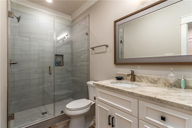 bathroom featuring a stall shower, vanity, and toilet