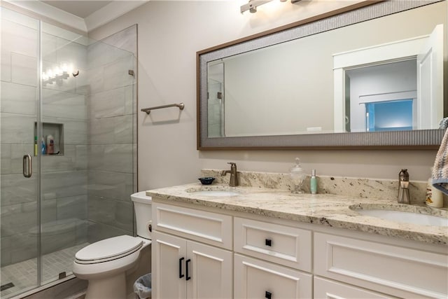 bathroom featuring double vanity, toilet, a stall shower, and a sink