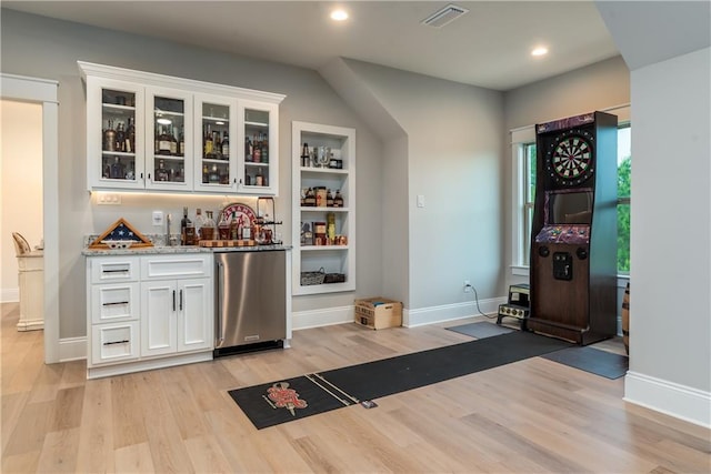 bar with indoor wet bar, light wood-style flooring, visible vents, fridge, and recessed lighting