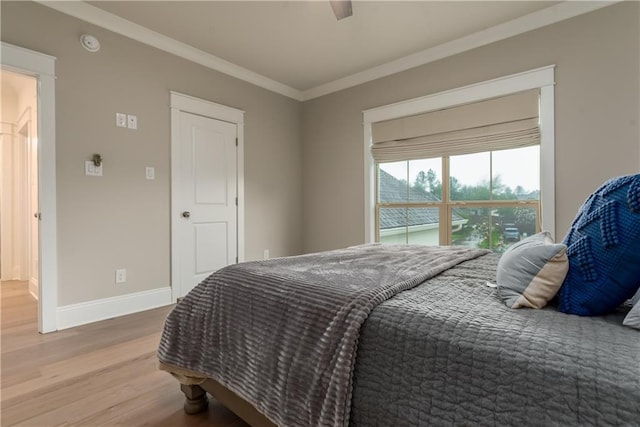 bedroom featuring baseboards, crown molding, and wood finished floors