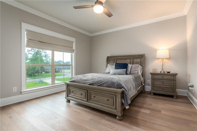 bedroom featuring light wood finished floors, ornamental molding, baseboards, and a ceiling fan