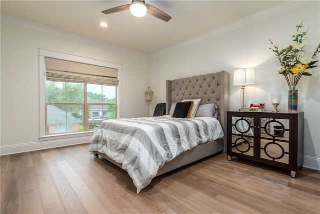 bedroom featuring baseboards, ceiling fan, light wood finished floors, and crown molding