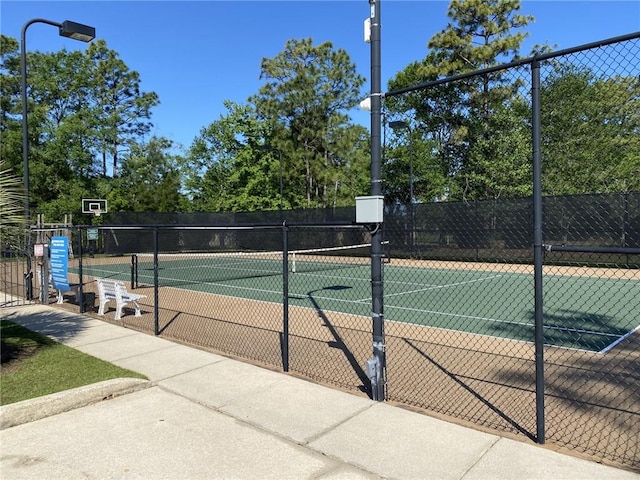 view of tennis court with fence and community basketball court