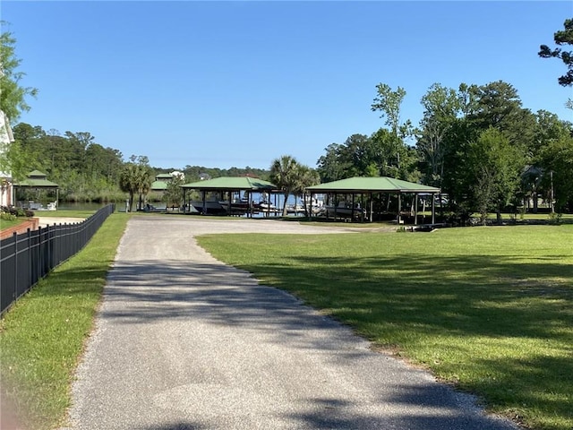view of community featuring a yard, fence, and a gazebo