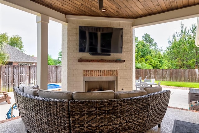view of patio / terrace with an outdoor living space with a fireplace and a fenced backyard
