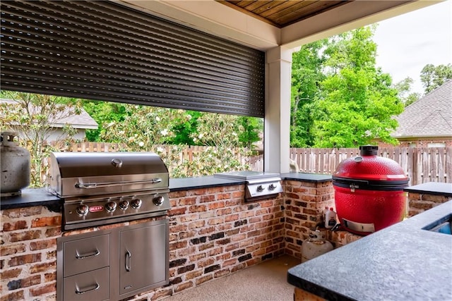 view of patio featuring a grill, an outdoor kitchen, and a fenced backyard