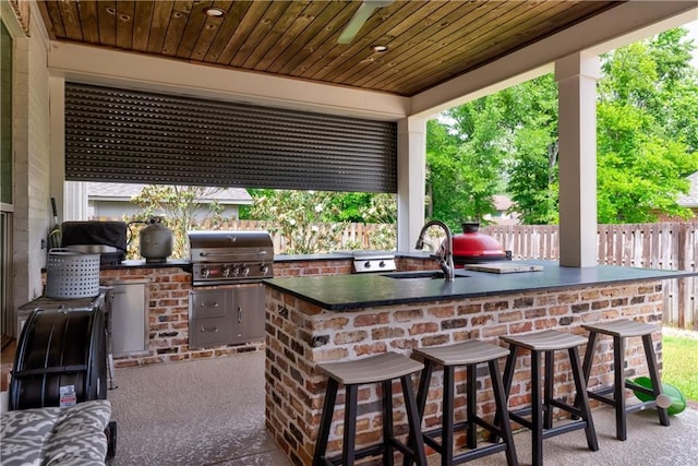 view of patio featuring a sink, area for grilling, exterior kitchen, and outdoor wet bar
