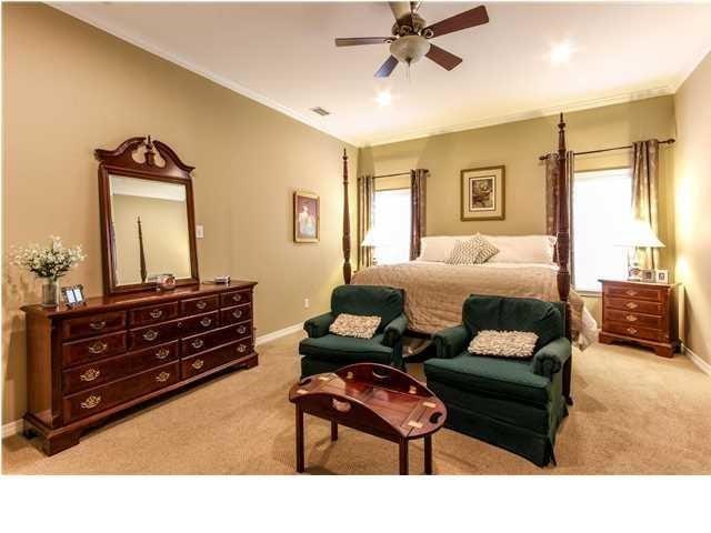 carpeted bedroom featuring ceiling fan, baseboards, and crown molding