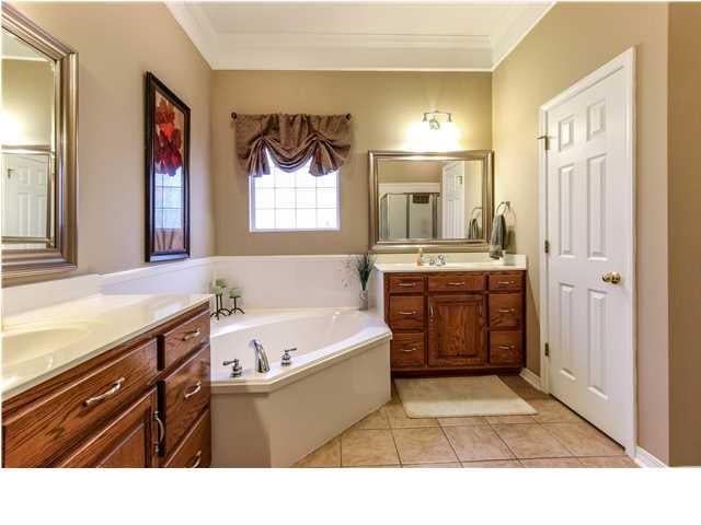 full bath with a sink, a garden tub, two vanities, and tile patterned floors