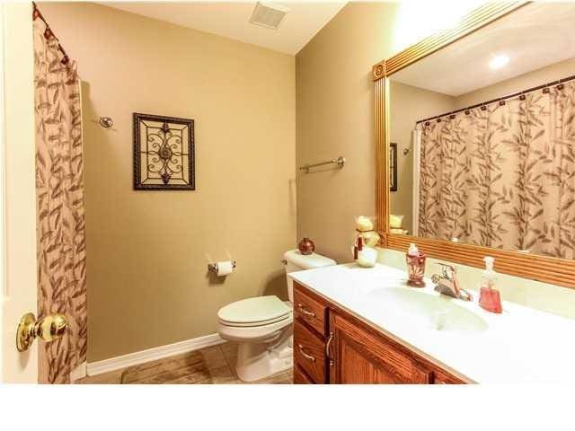 bathroom featuring visible vents, vanity, toilet, and baseboards