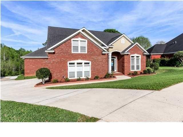 view of front facade featuring driveway, brick siding, and a front yard