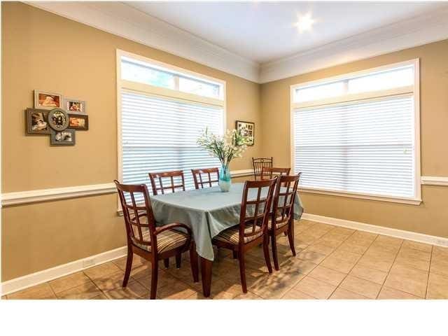 dining room with ornamental molding, light tile patterned flooring, and baseboards