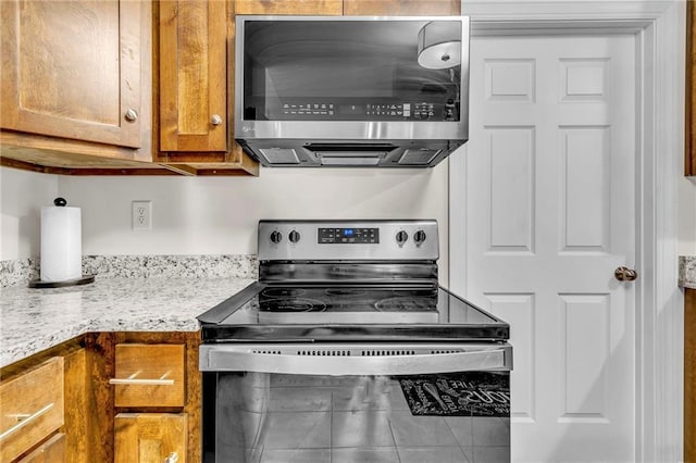 1933 Wildwood Pl, Mobile, AL 36609 - kitchen with brown cabinets, stainless steel appliances, and light stone countertops