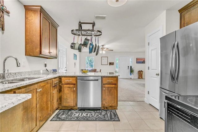 1933 Wildwood Pl, Mobile, AL 36609 - kitchen featuring stainless steel appliances, brown cabinetry, a sink, and a peninsula