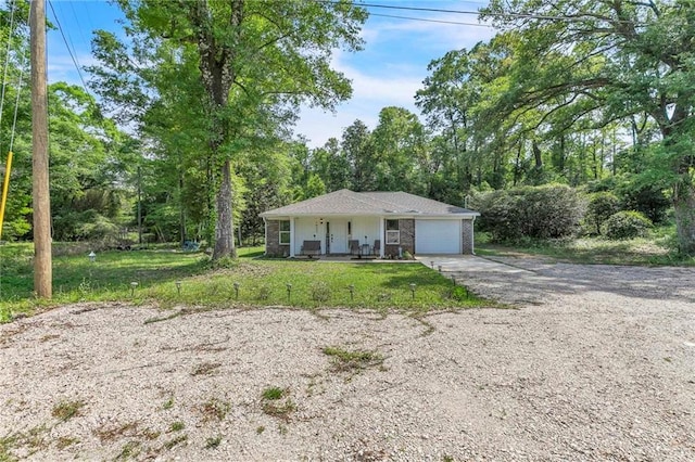1933 Wildwood Pl, Mobile, AL 36609 - view of front of house with an attached garage, a front lawn, brick siding, covered porch, and driveway