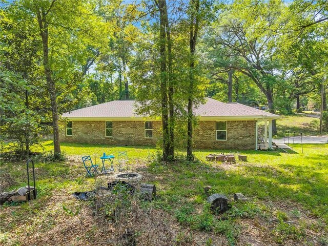 1933 Wildwood Pl, Mobile, AL 36609 - rear view of house featuring a yard, brick siding, and an outdoor fire pit