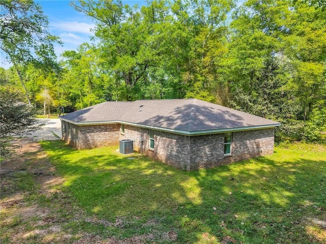 1933 Wildwood Pl, Mobile, AL 36609 - view of side of home featuring roof with shingles, a yard, cooling unit, and brick siding