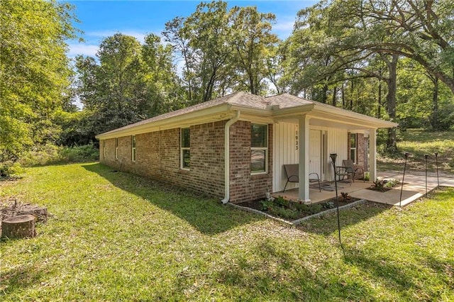 1933 Wildwood Pl, Mobile, AL 36609 - view of side of property with a yard, brick siding, and a patio area