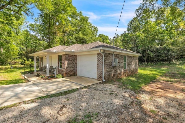 1933 Wildwood Pl, Mobile, AL 36609 - view of front facade with brick siding, a garage, driveway, and covered porch