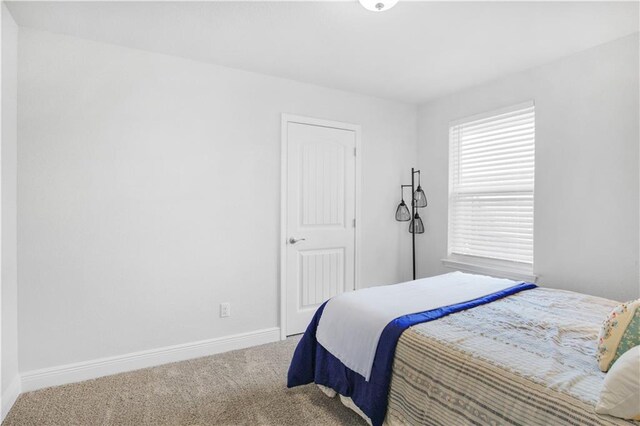 carpeted bedroom featuring baseboards