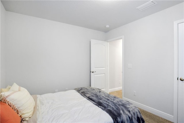 bedroom featuring carpet floors, visible vents, and baseboards