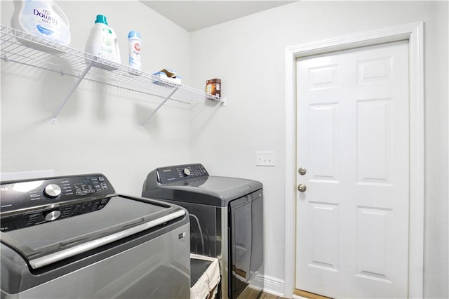 washroom featuring laundry area, independent washer and dryer, baseboards, and wood finished floors