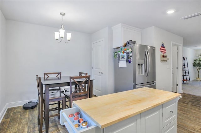 kitchen featuring stainless steel refrigerator with ice dispenser, butcher block counters, visible vents, dark wood-type flooring, and white cabinetry